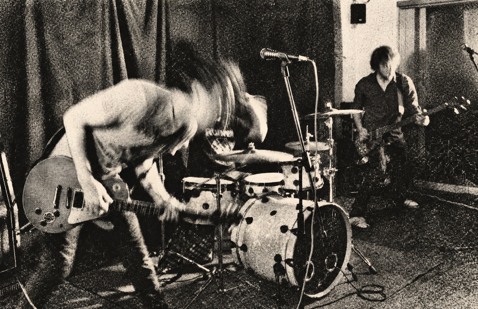Jumpin' Juice live with motion-blurred guitar playing — black-and-white halftone