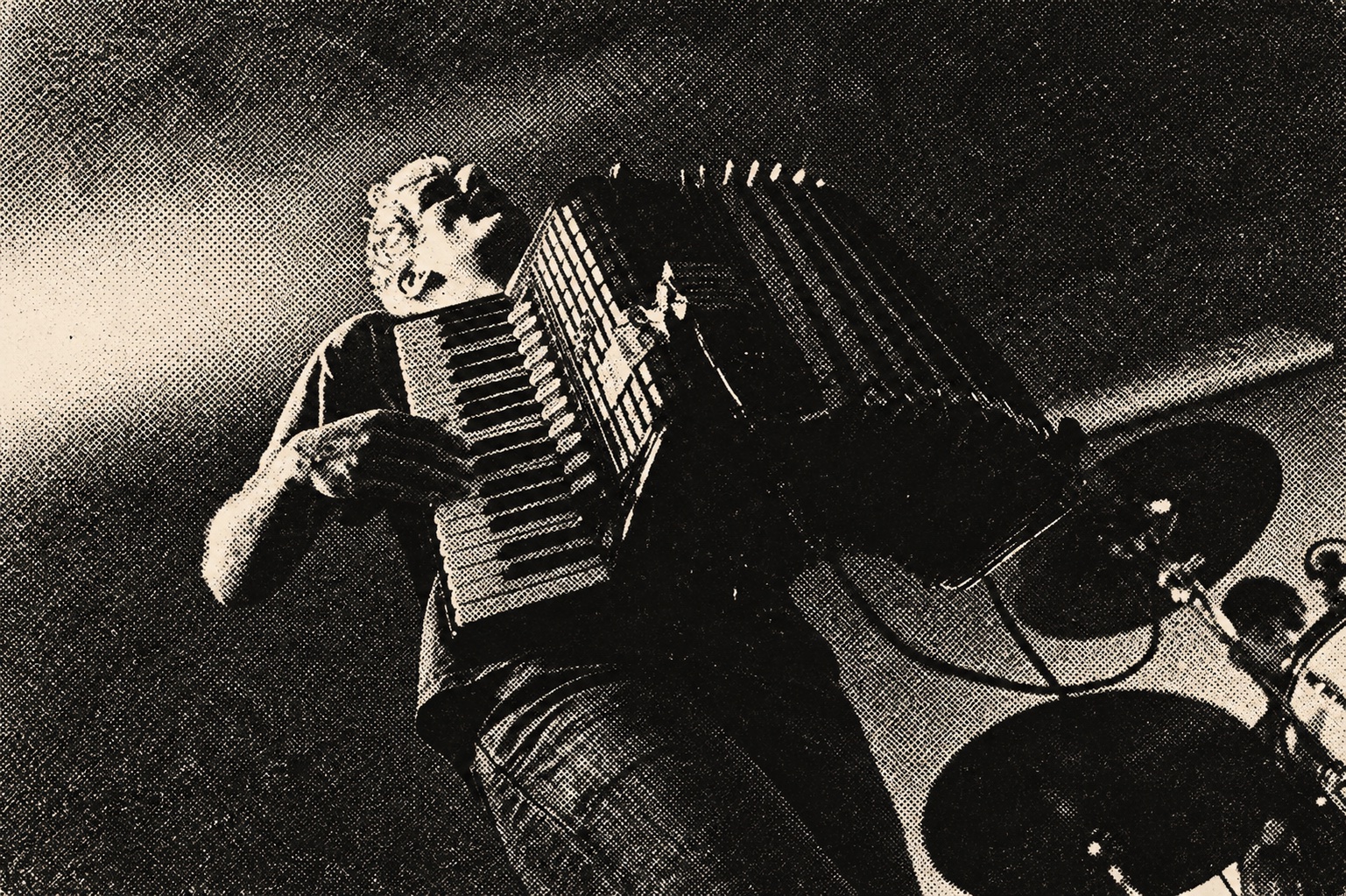 Hans Stübinger playing accordion, photographed from below — black-and-white halftone