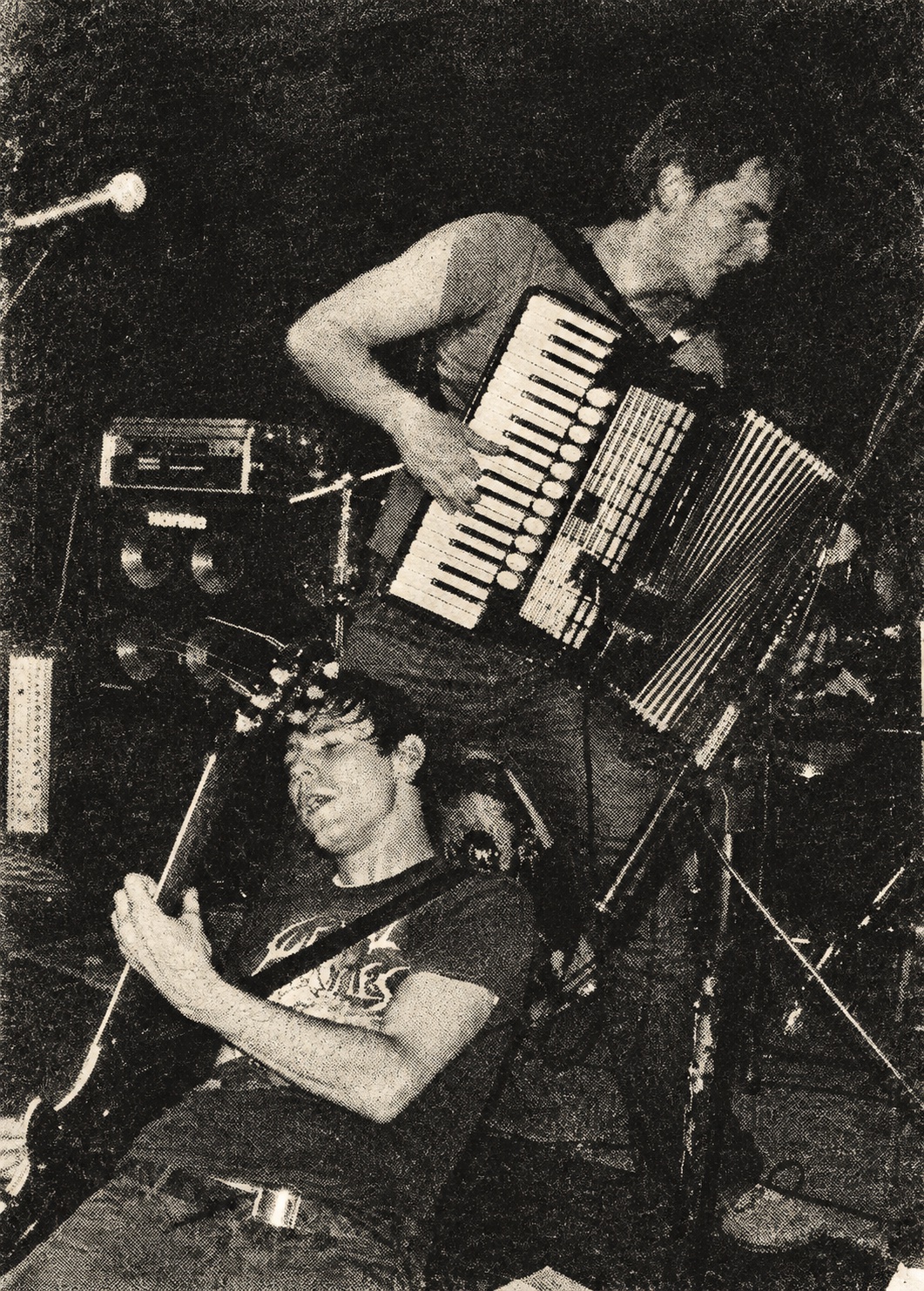 Accordion and guitar players during an energetic live performance — black-and-white halftone